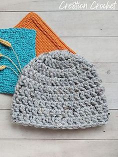 two crocheted dishcloths sitting next to each other on a wooden surface