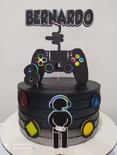 there is a black cake with video game controllers on it