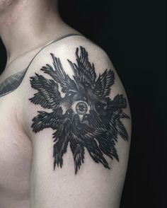 a man's shoulder with a black and white tattoo design on the upper half of his arm