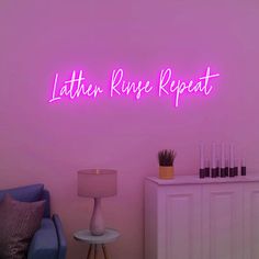 a living room with a purple wall and neon sign on the wall that says lather rinsee repeat