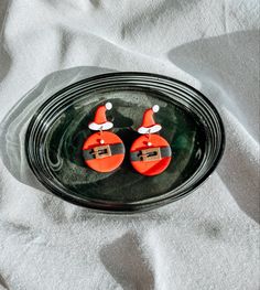 two red santa hats sitting on top of a glass plate