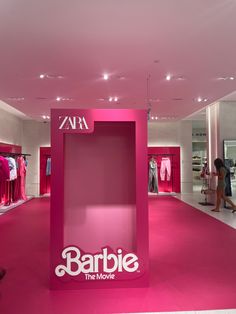 the interior of a clothing store with pink carpeting and clothes on mannequins