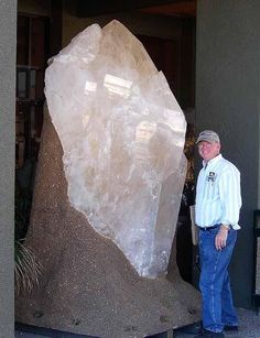 a man standing in front of a large rock