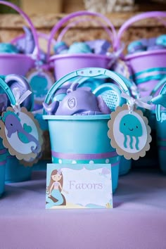 blue and purple buckets filled with toys on top of a table