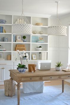 a desk with a laptop on top of it in front of a bookshelf