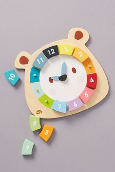 a wooden clock with colorful numbers and a bear face