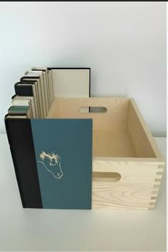 a wooden box filled with books on top of a table