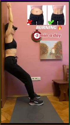 a woman standing on top of a yoga mat in front of a pink wall with her hands up