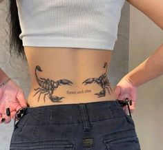 a woman is holding her stomach with two scorpions on it and the words believe and love written in black ink