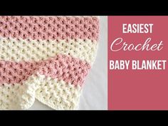 a crocheted baby blanket with pink and white stripes on the bottom, next to it