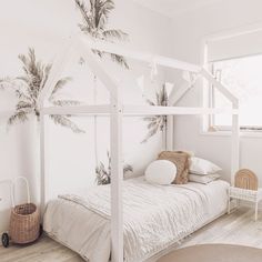 a white bedroom with palm trees on the wall