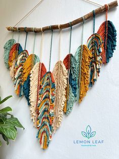 a wall hanging made out of different colored fabrics and wood sticks with the words lemon leaf on it