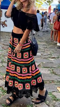 a woman in a black top and colorful skirt