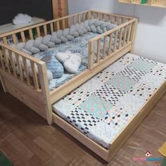 a wooden crib with a mattress and stuffed animals on the bottom bed, in a child's room