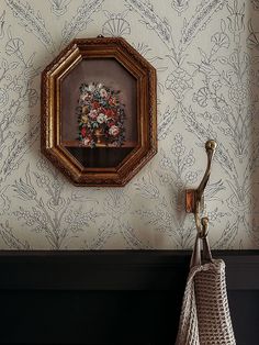 a vase with flowers is hanging on the wall next to a mirror and umbrella holder