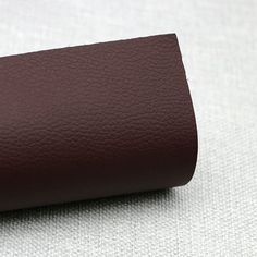 a roll of brown leather sitting on top of a white surface