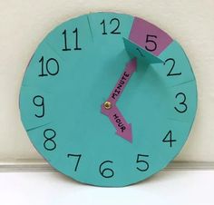 a blue clock with pink tape on the face and words learning clock written across it