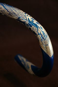 a close up of a blue and silver object with designs on it's side