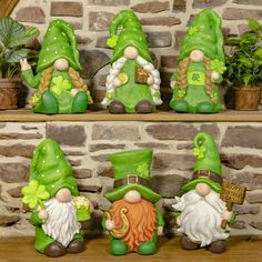 four green gnomes sitting next to each other on a shelf