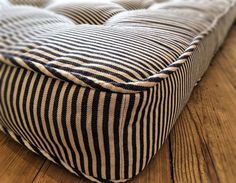 a black and white striped seat cushion on a wooden floor