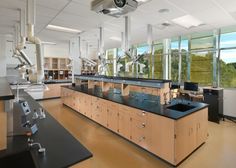 an empty laboratory with lots of counter tops and lab equipment on the counters in front of large windows