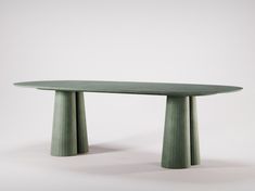 a green table sitting on top of a white floor