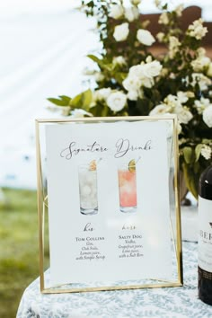 a table topped with two bottles of wine and a sign