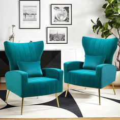 two teal chairs sitting next to each other in front of a black and white rug