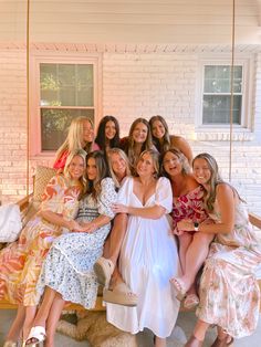 a group of women sitting on top of a porch swing