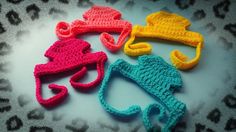 three crocheted hats sitting on top of a table