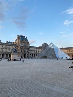 a man standing in front of a large building with a pyramid on it's side