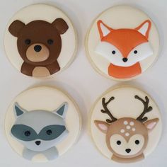 four decorated cookies in the shape of animals and deers on top of each other