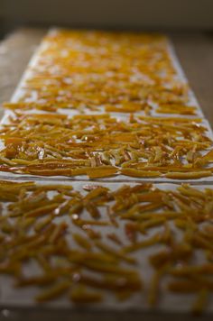 orange peels sitting on top of a white table covered in yellow wax and other things