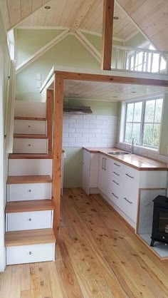 an open loft with stairs leading up to the kitchen