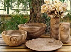 three vases with flowers in them are sitting on a table next to some baskets