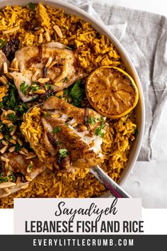 a bowl filled with rice, chicken and lemons next to a napkin on the side