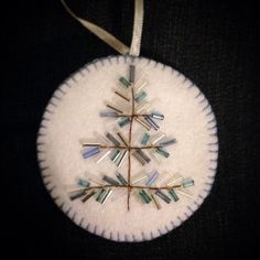 a snowflake ornament is hanging on a black cloth with a white ribbon