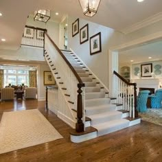 a living room filled with furniture next to a stair case on top of a hard wood floor