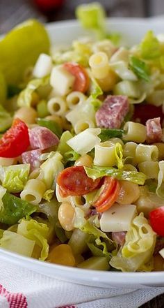 a white bowl filled with pasta salad on top of a table