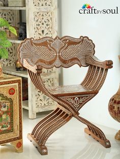 a wooden chair sitting on top of a white floor next to vases and other items