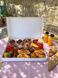 a white box filled with lots of food on top of a table next to bread