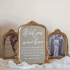 two gold framed pictures sitting on top of a white table next to a wedding cake