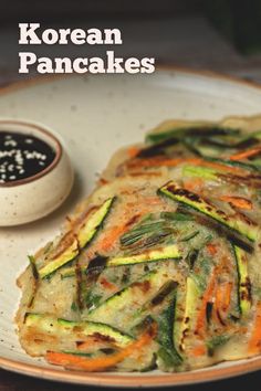 a plate with some food on it and a small bowl next to it that says korean pancakes