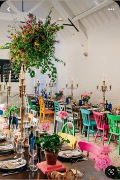 a dining room filled with lots of colorful chairs and tables covered in plates and flowers