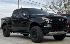 a large black truck parked in a parking lot