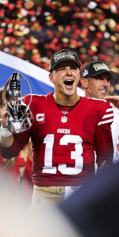 the football player is holding up his trophy