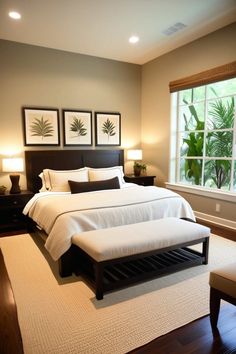 a bedroom with a large bed and two framed pictures on the wall