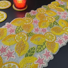 a table topped with lots of yellow lemons next to a candle