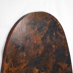 a large metal object on a white surface with rusted pattered paint and wood trim