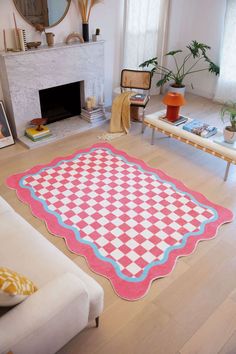 a living room filled with furniture and a rug on top of a hard wood floor